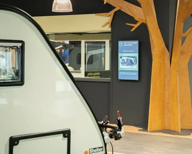 Verticaal informatiescherm aan een showroomwand / écran d’information vertical dans un showroom