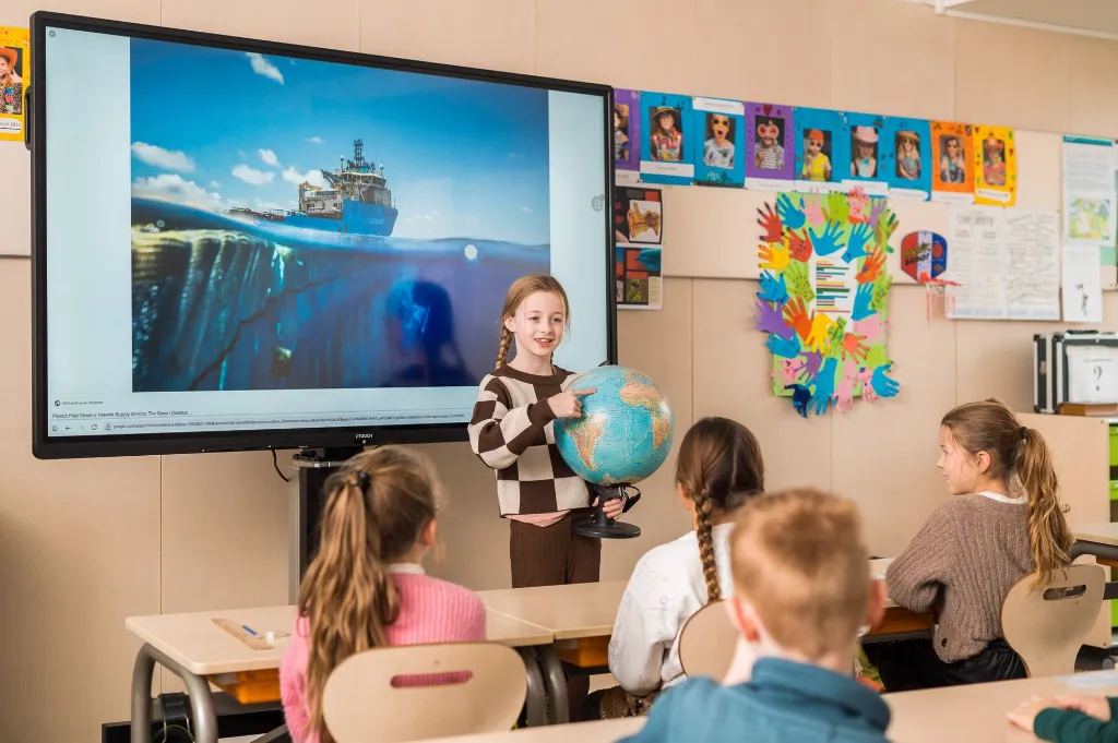 Leerling presenteert met een globe voor een CTOUCH scherm / élève présentant un globe devant un écran CTOUCH