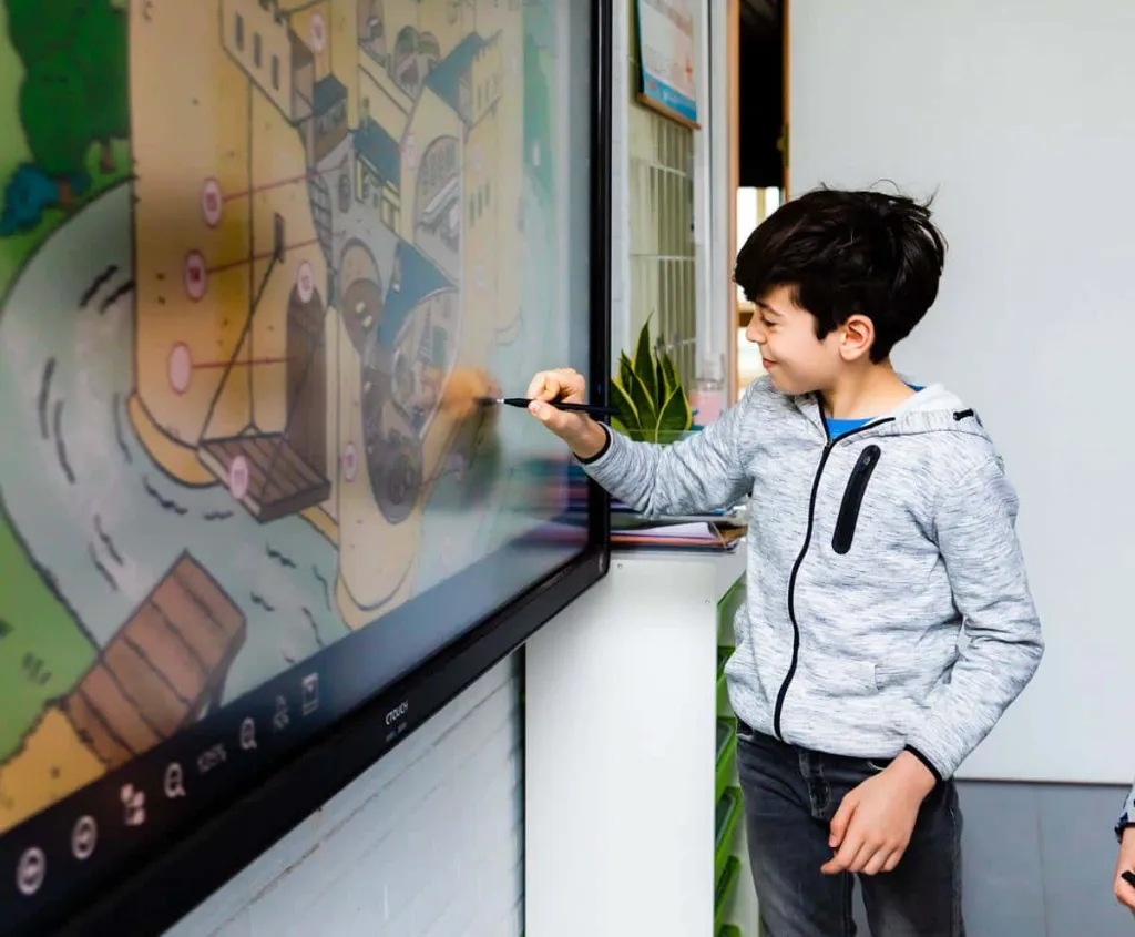 Leerling schrijft met een pen op een interactief scherm / élève écrivant avec un stylet sur un écran interactif