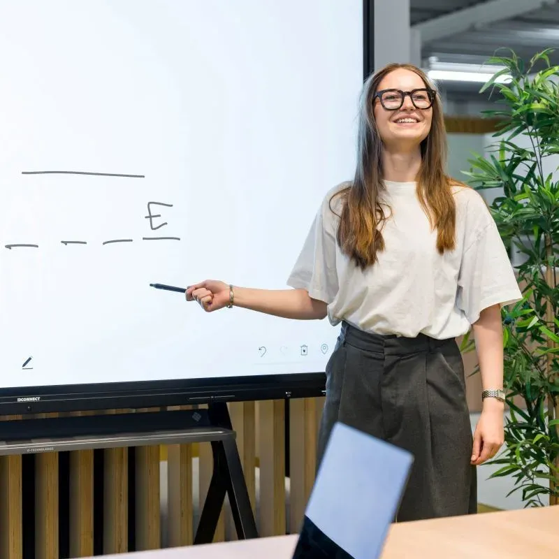 Presentatrice met pen voor een interactief whiteboard / présentatrice avec stylet devant un tableau interactif